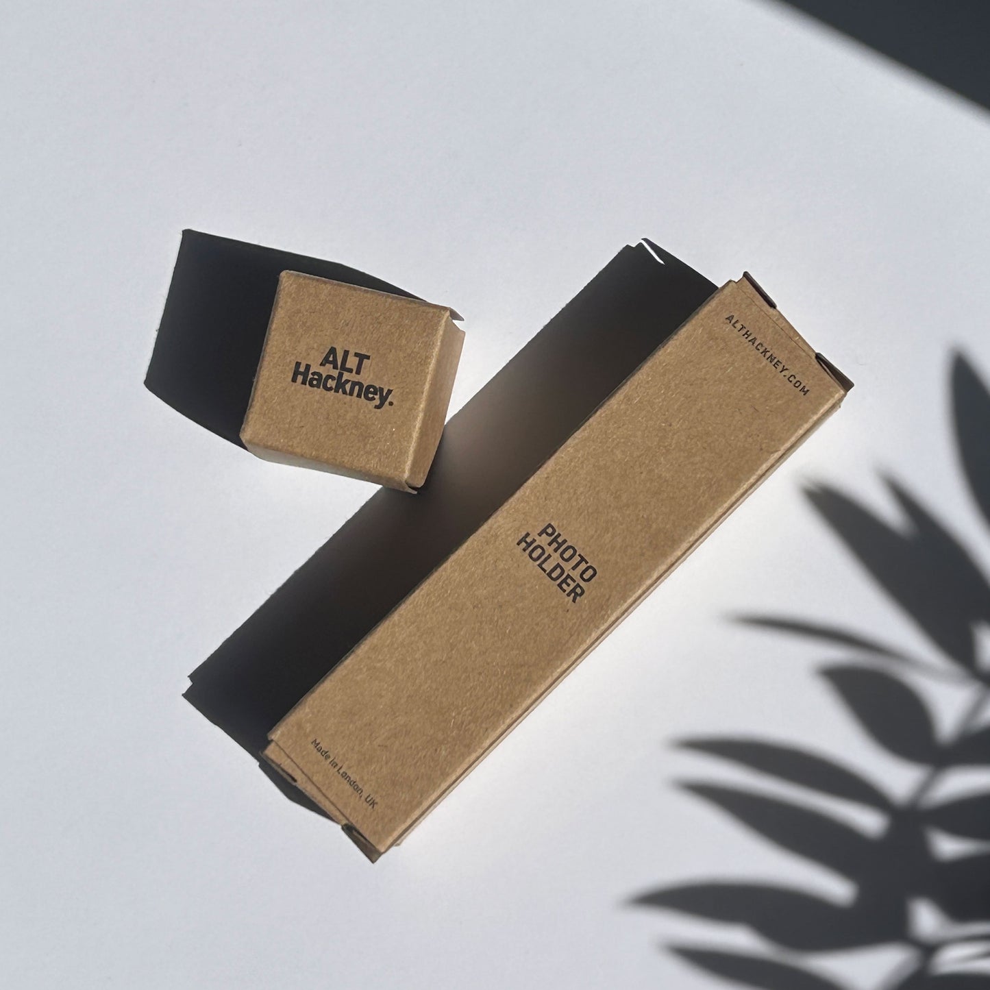 Brown eco photo holder boxes with 'ALT Hackney' branding on a light surface.