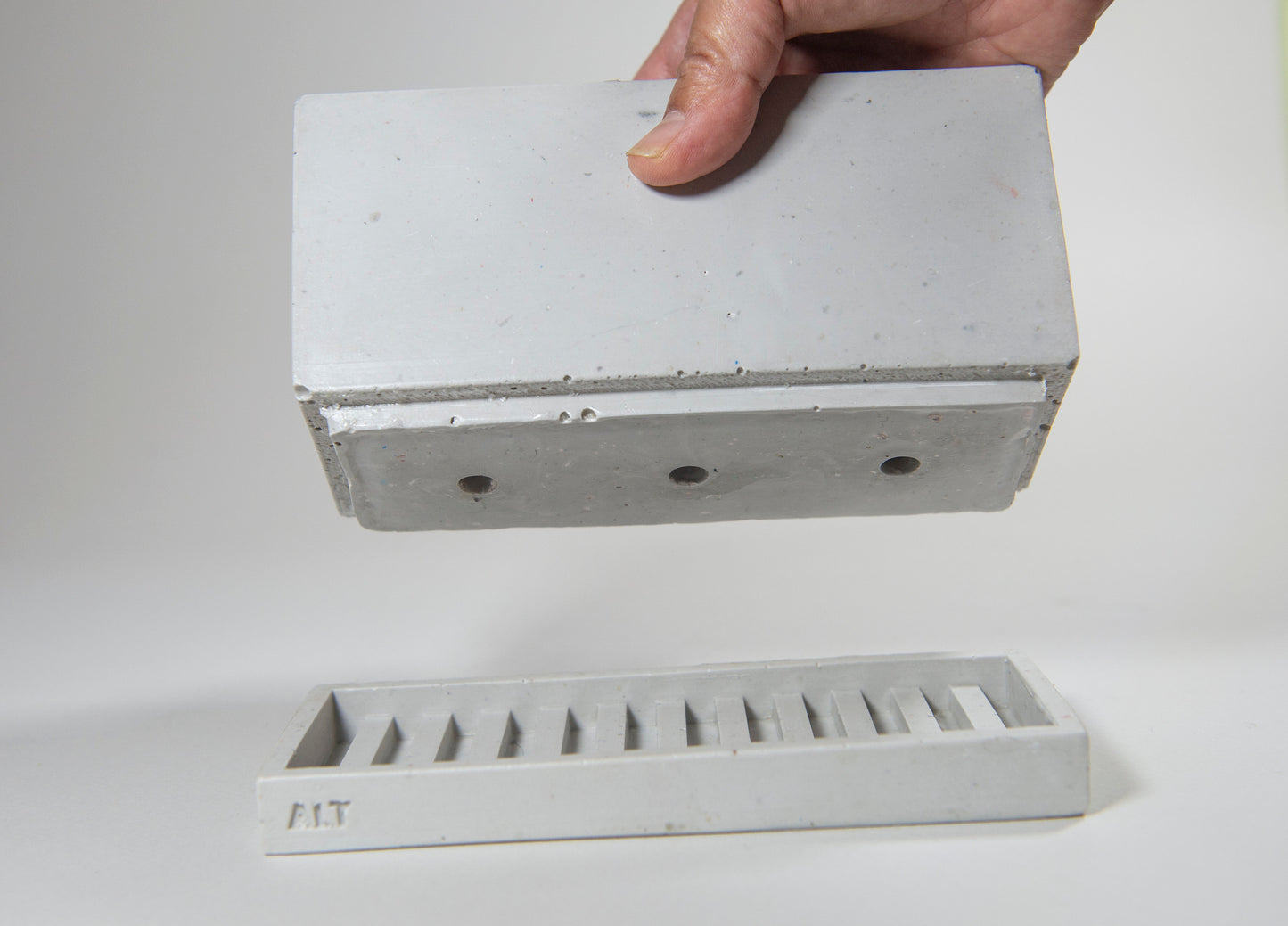 Rectangular grey planter with drainage holes and a water tray box with 'ALT' branding on a white background