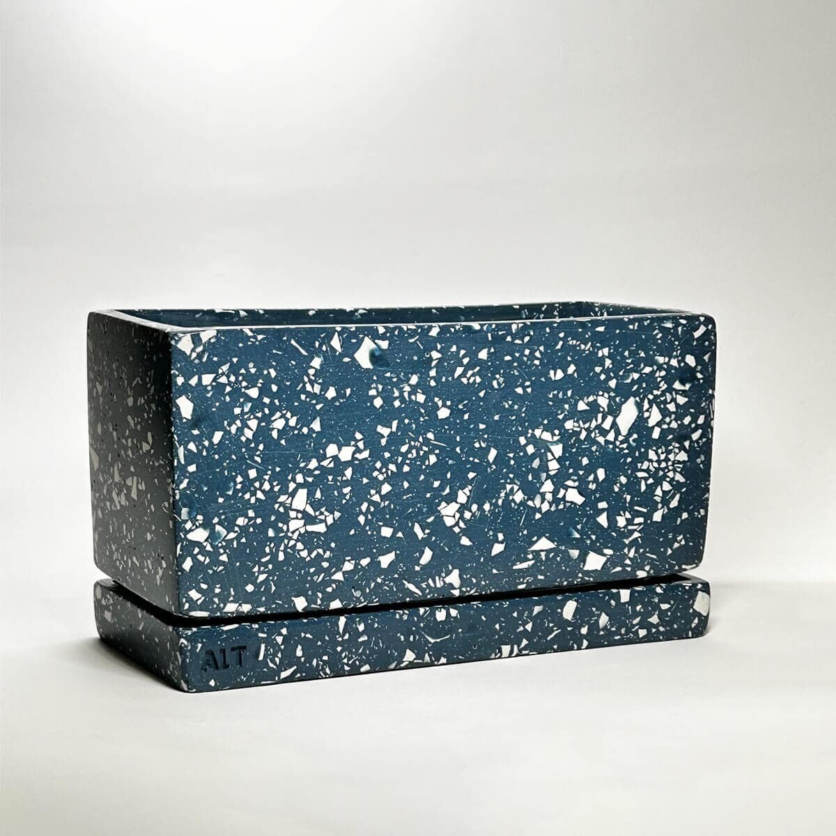 Navy rectangular terrazzo planter with drainage holes and a water tray on a white background