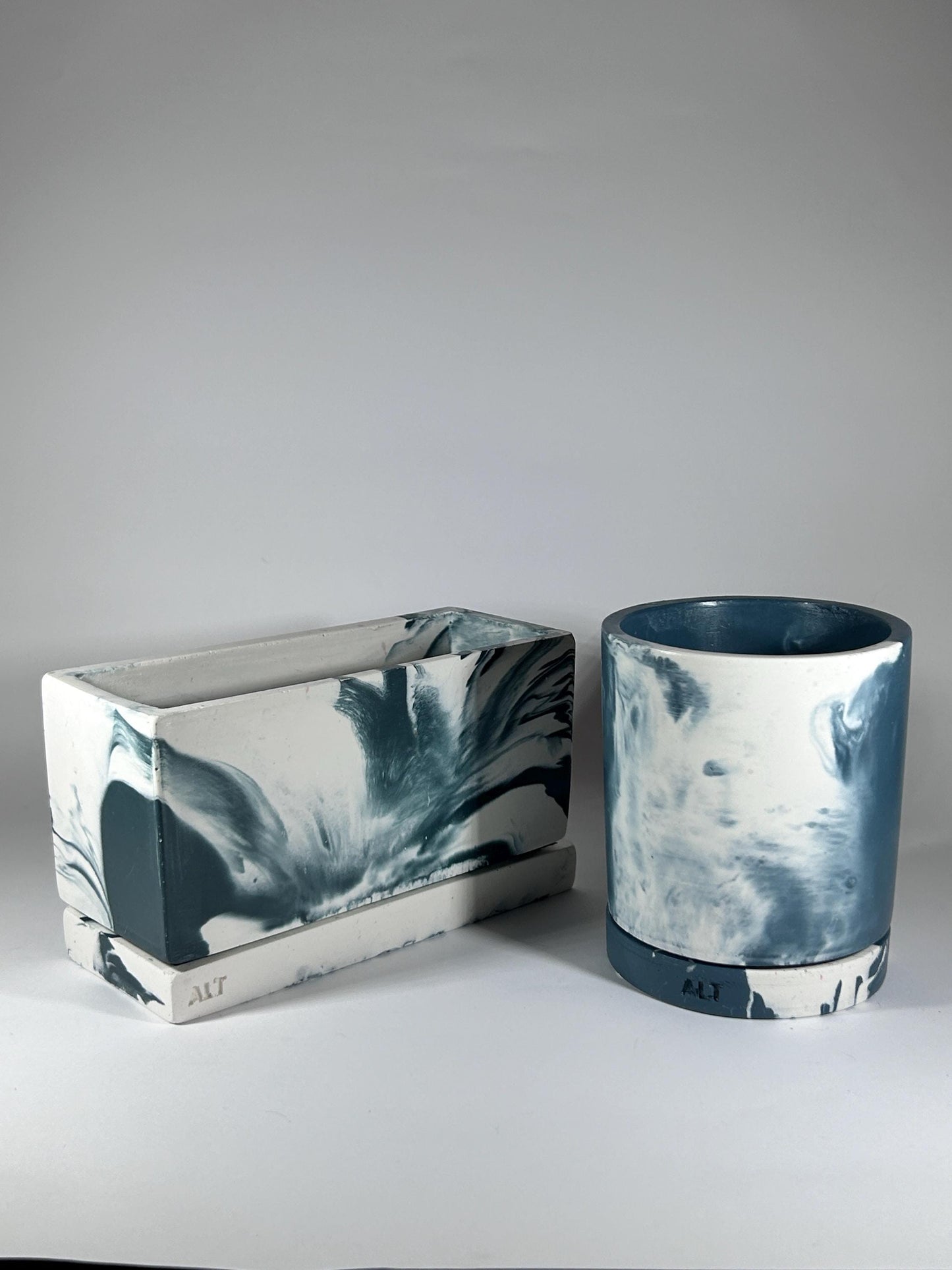 Two plant pots with marbled blue and white design on a grey background