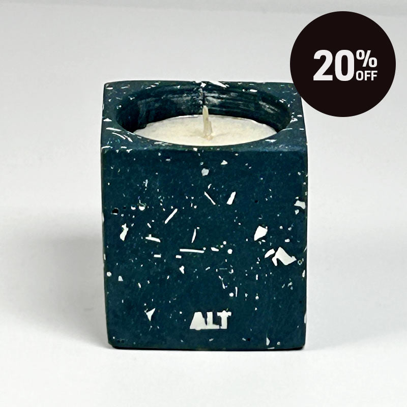 A rectangular navy candle holder with white terrazzo, containing a white tea light candle. The word 'ALT' is printed in white near the bottom front. With 20% off badge