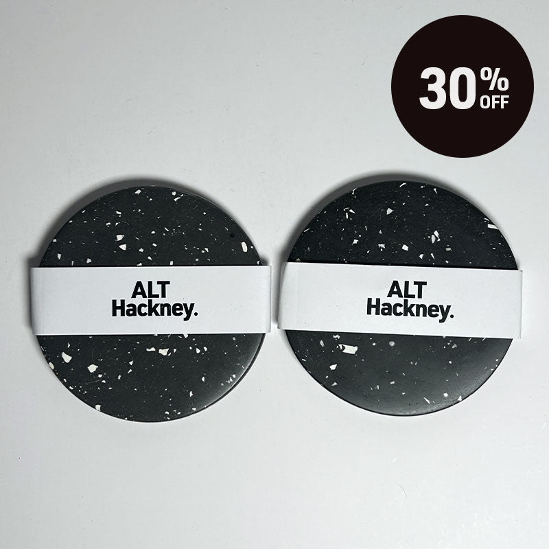Two round coasters with a black and white terrazzo pattern and a white band across the middle reading 'ALT Hackney.' on a light grey background, with a black circular '30% OFF' badge in the top right corner.
