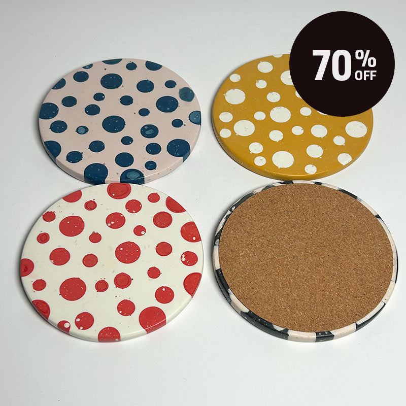 Four round coasters arranged in a 2x2 grid on a white background, showing both sides: one side has colorful polka dots (blue on beige, white on mustard yellow, red on white), and the other side shows a natural cork backing. A black circular '70% OFF' sticker is in the top right corner.