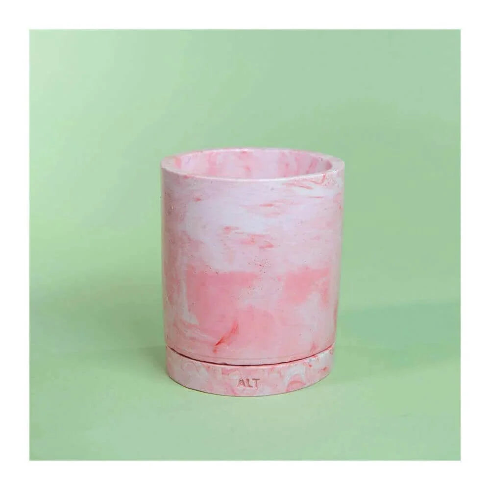 Pink marbled plant pot displayed against a green background.