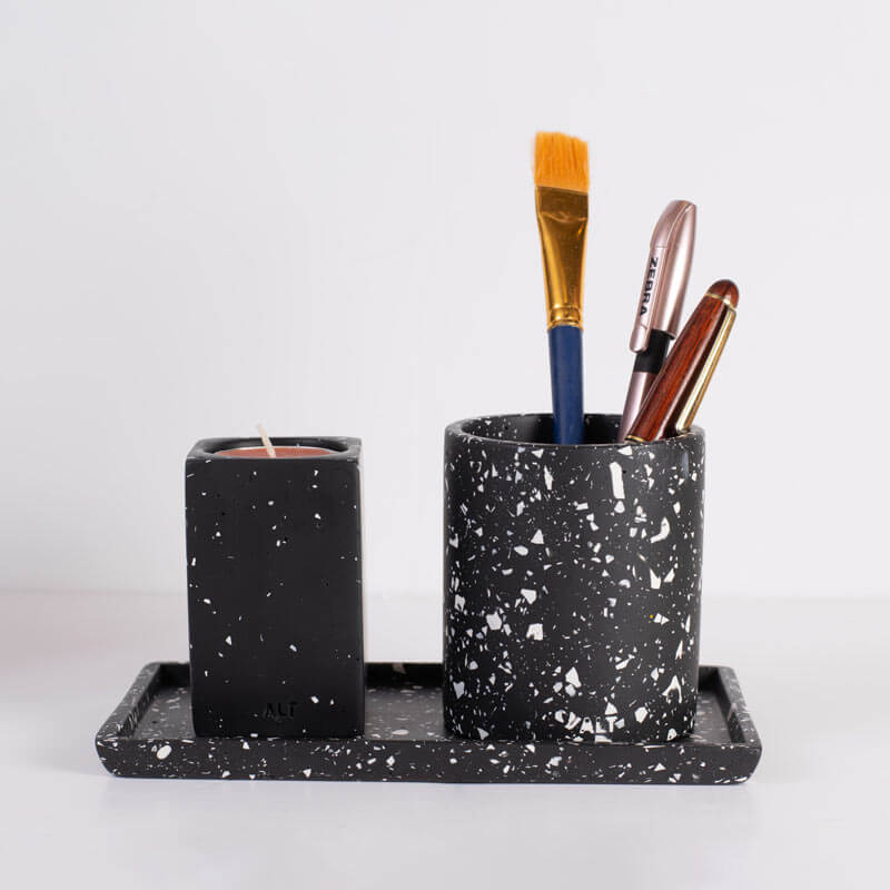 Black speckled ceramic set with a candle, tray, and paintbrushes on a white background
