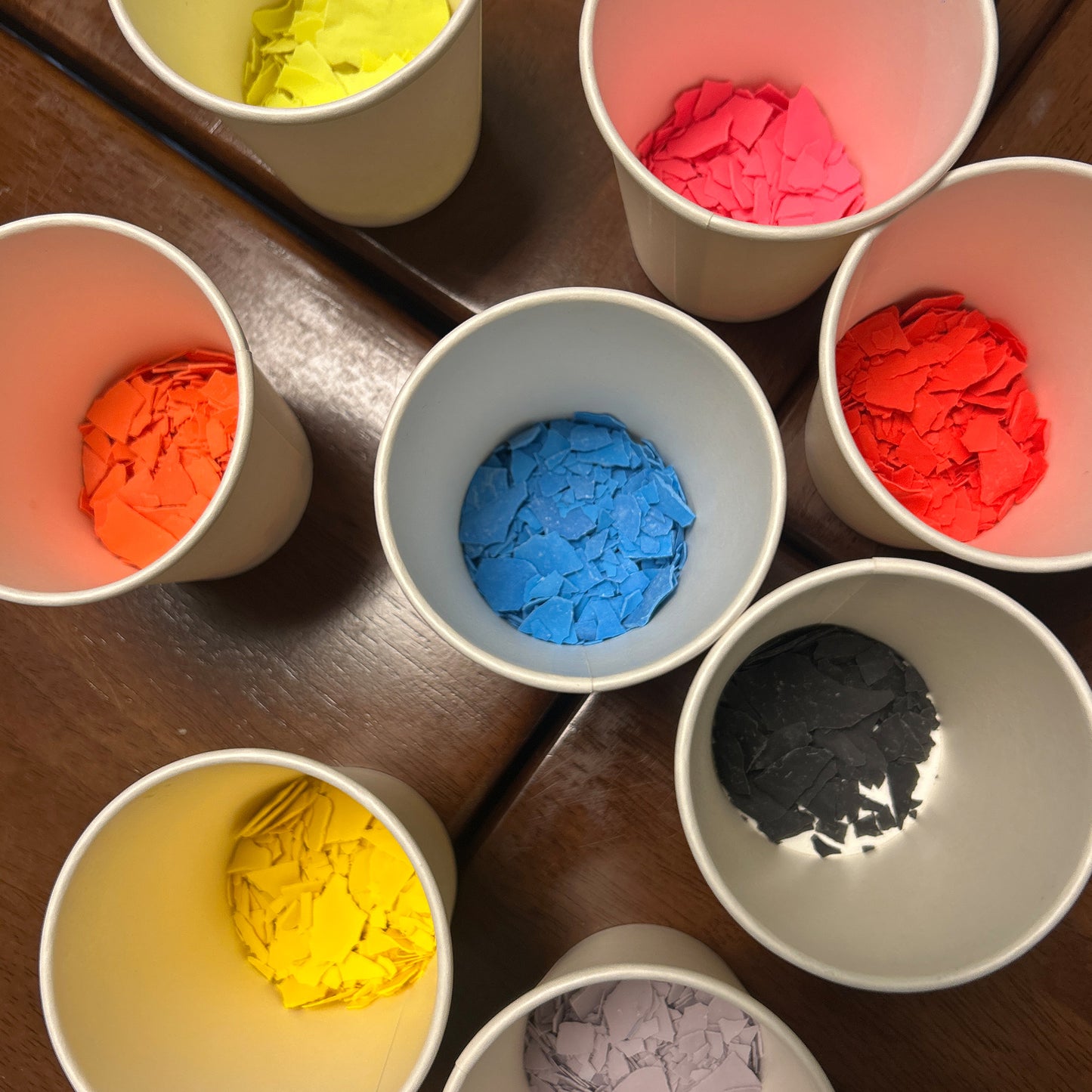 Cups filled with colourful confetti terrazzo on a wooden surface