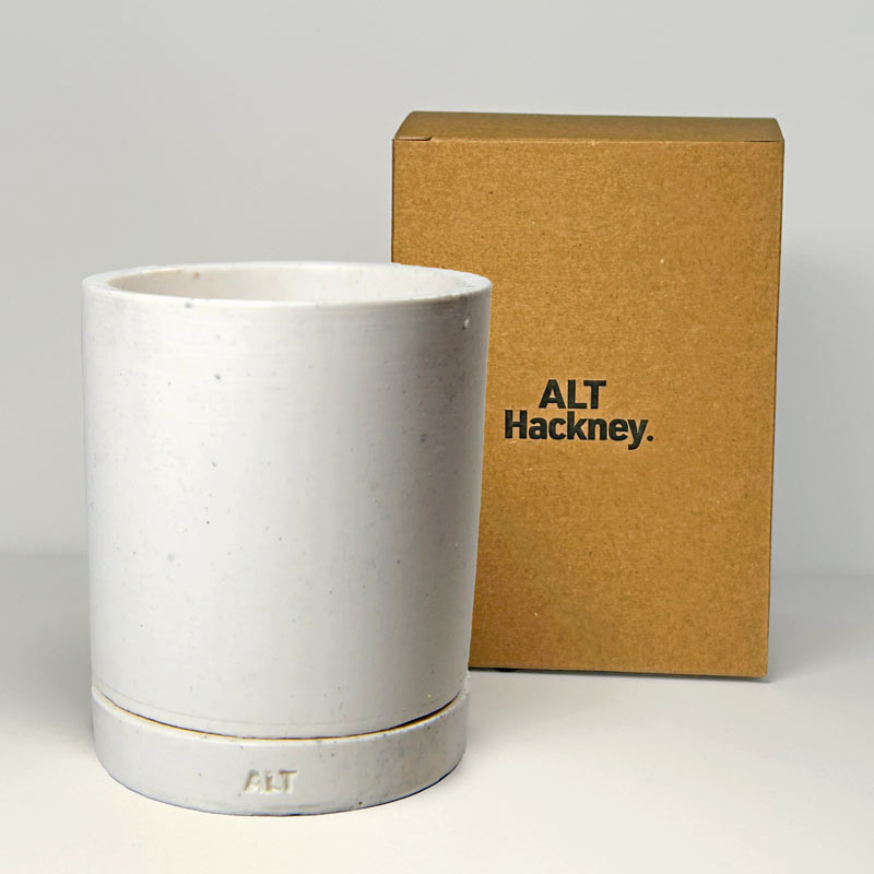 White Jesmonite planter with 'ALT Hackney' branding next to a brown box on a gray background