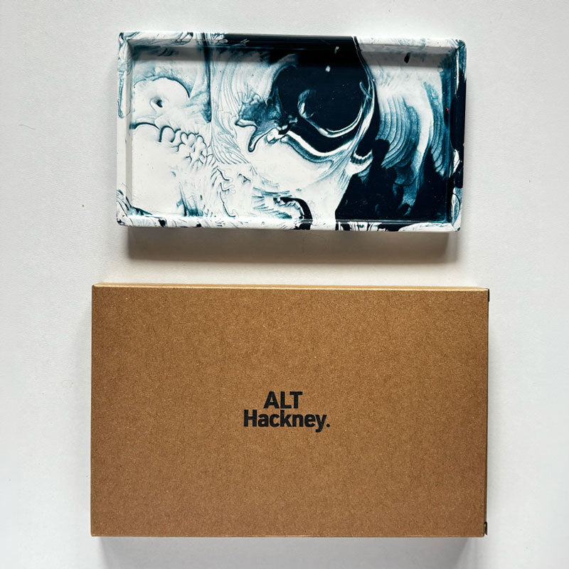 Marble-patterned navy rectangular tray with a brown eco packaging box with 'ALT Hackney' branding.