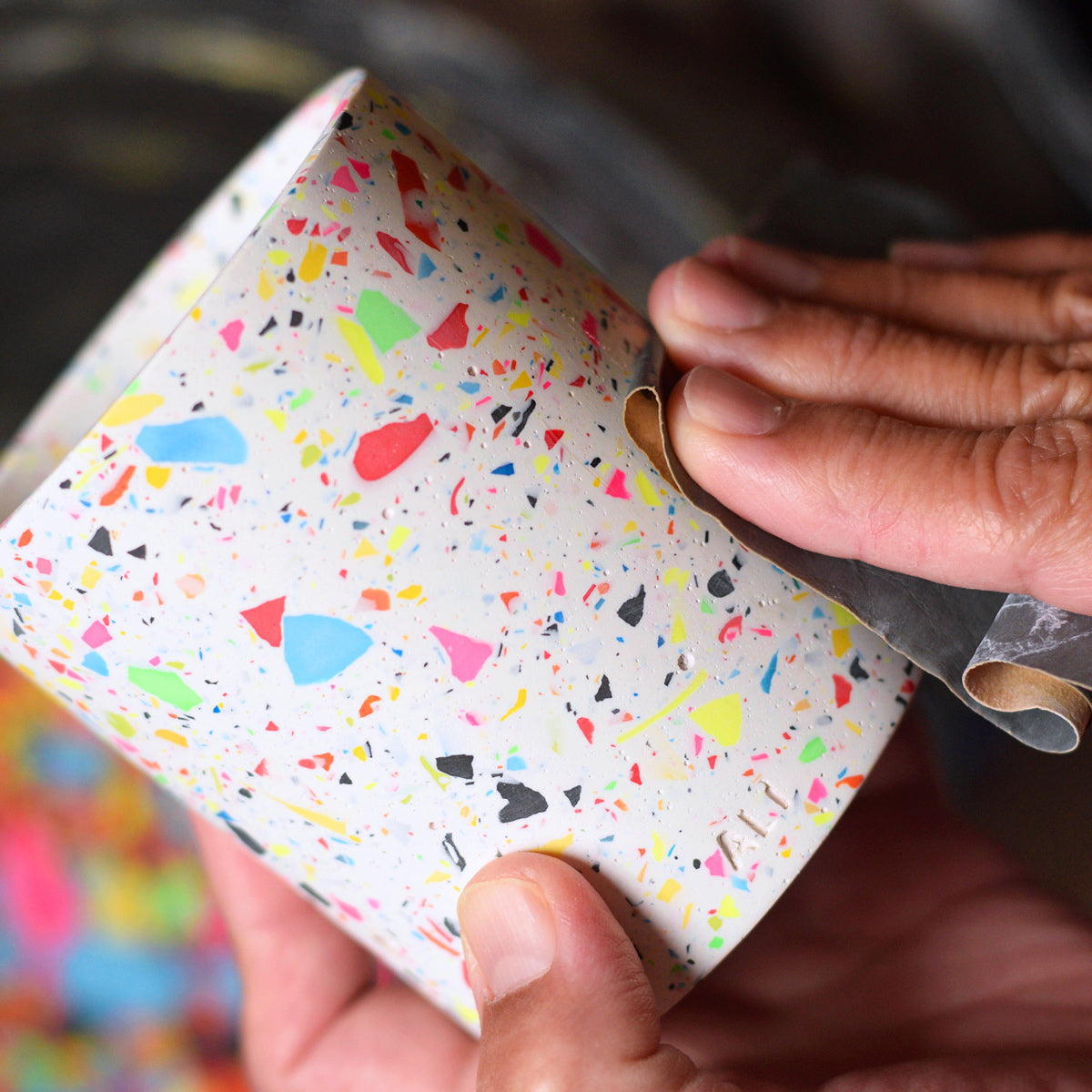 Hand sanding the surface of a terrazzo pen pot