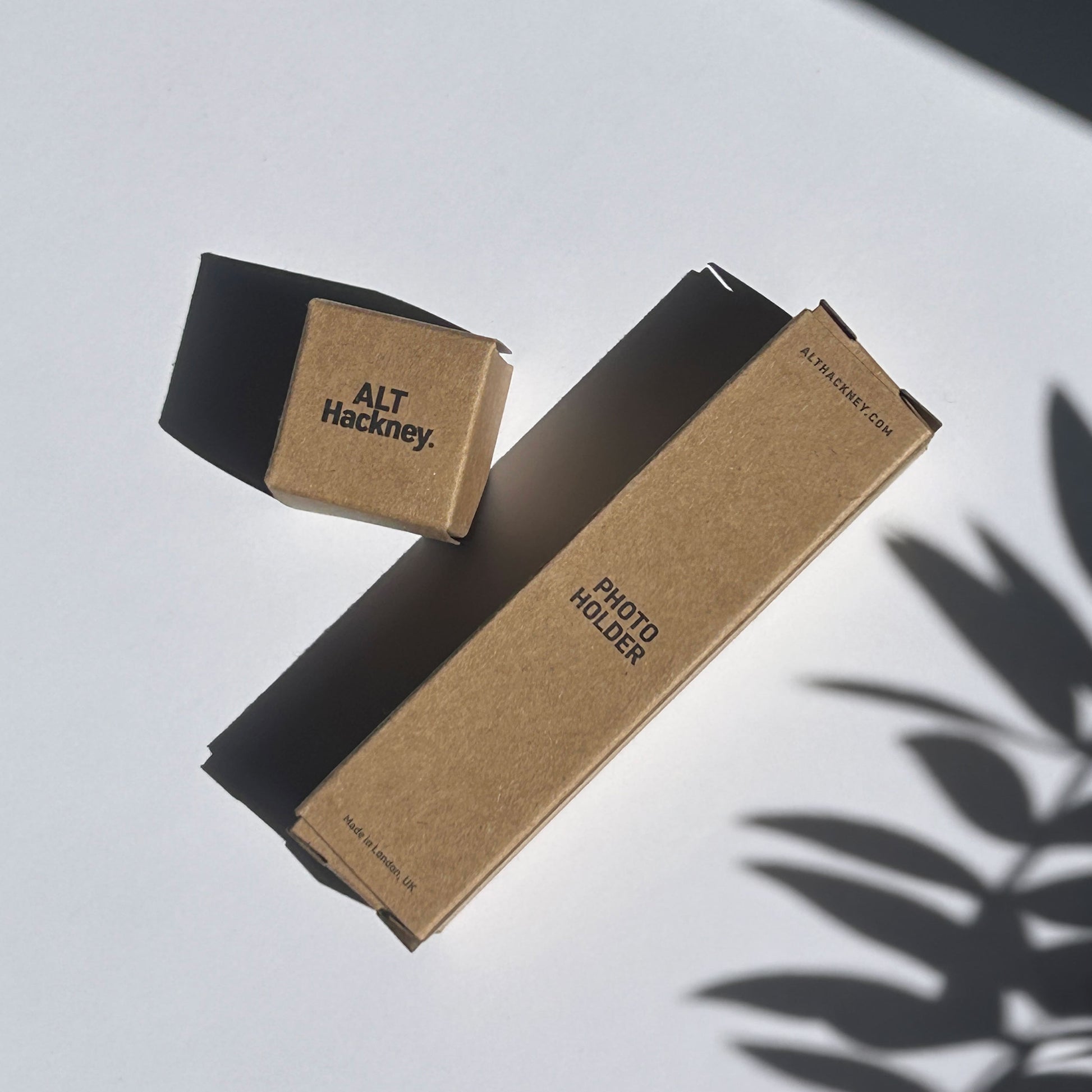 Brown eco photo holder boxes with 'ALT Hackney' branding on a light surface.