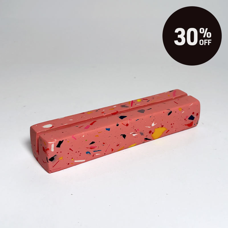 A terrazzo-patterned rectangular photo holder in coral pink, shown on a clean white studio background with a black circular '30% OFF' promotional badge in the top right corner.