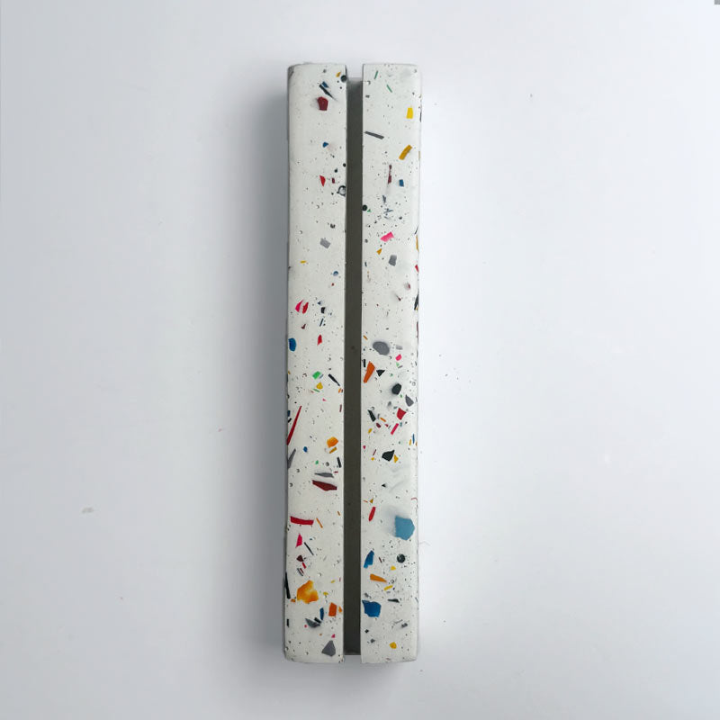 A raibbow terrazzo-patterned photo stand on a light grey boackground