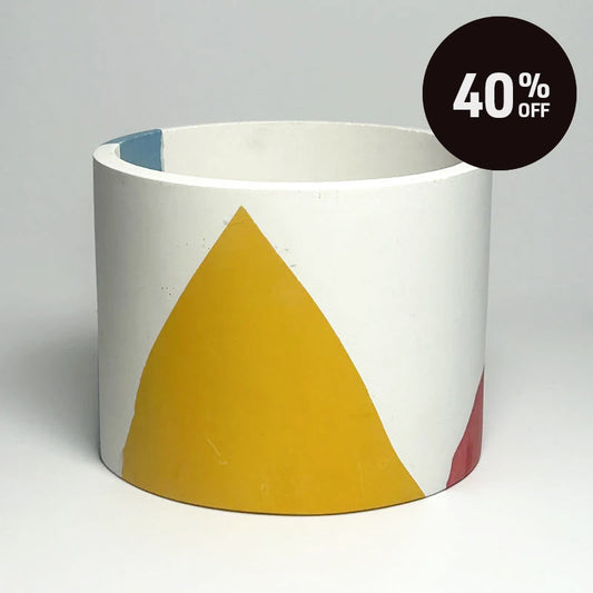 A cylindrical planter with a white base decorated with a large mustard yellow triangle and small accents of blue and red, shown on a neutral gray background with a '40% OFF' promotional sticker in the top right corner.