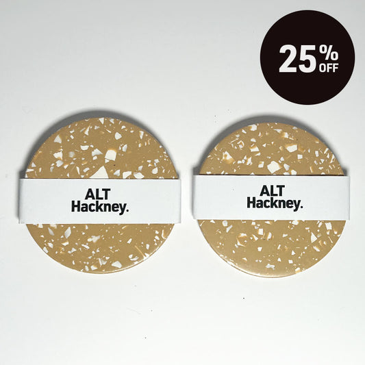 Two round terrazzo-patterned coasters with white ALT Hackney. bands, shown on a white background with a black 25% OFF discount badge in the top right corner.
