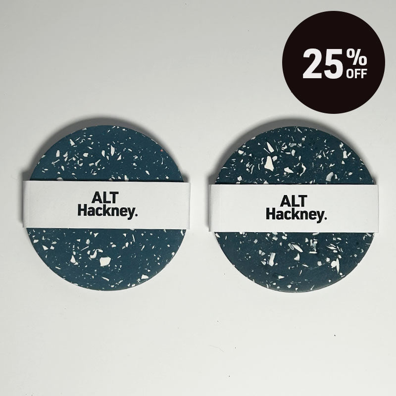 Two round coasters with a dark navy and white terrazzo pattern and a white band across the middle reading 'ALT Hackney.' on a light gray background, with a black circular '25% OFF' badge in the top right corner.