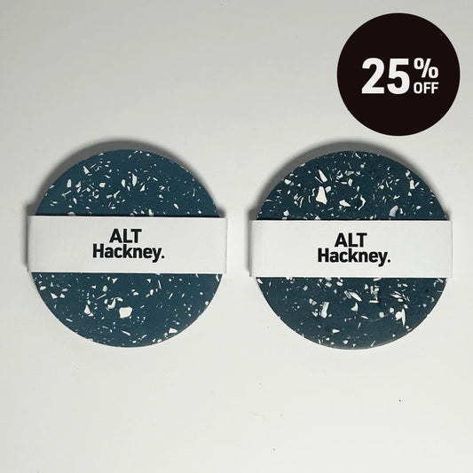 Two round coasters with a dark navy and white terrazzo pattern and a white band across the middle reading 'ALT Hackney.' on a light gray background, with a black circular '25% OFF' badge in the top right corner.