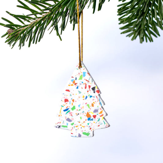 Rainbow terrazzo tree-shaped Christmas decoration hanging on a Christmas tree branch