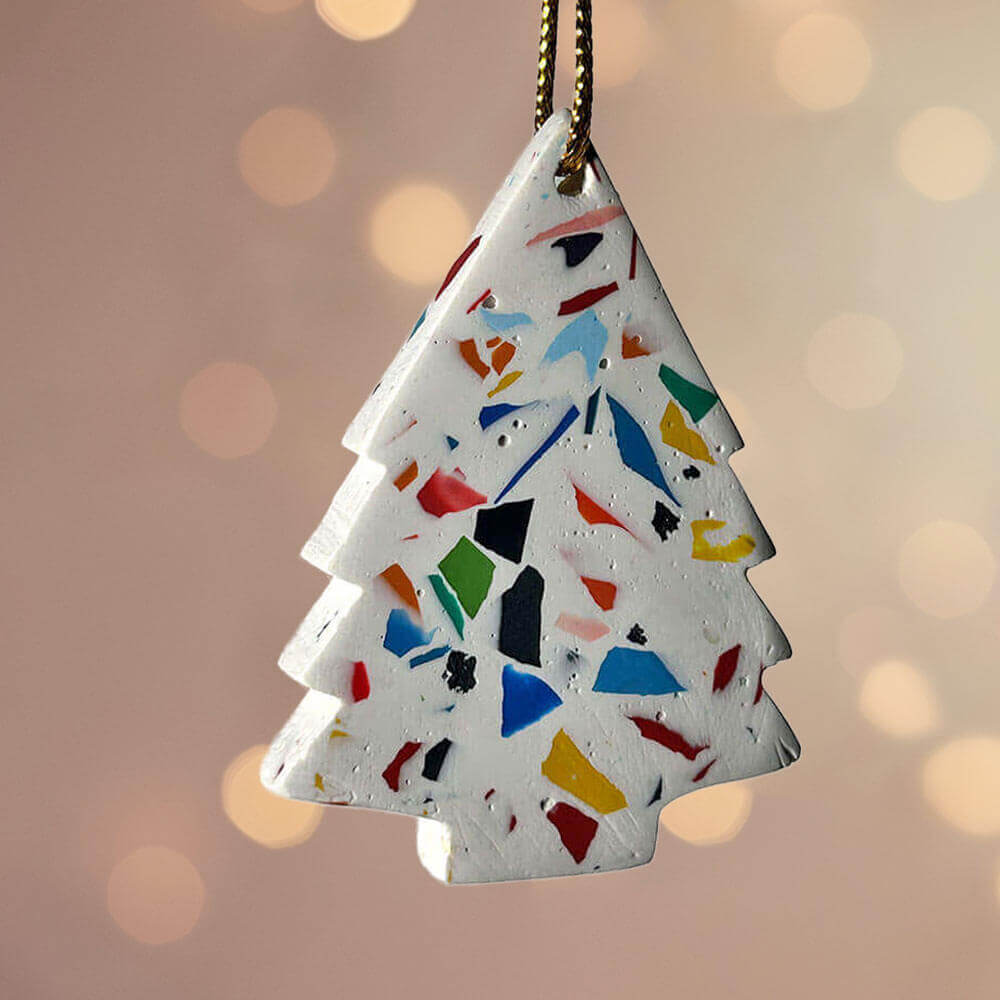 Rainbow terrazzo-patterned Christmas tree ornament on a blurred background