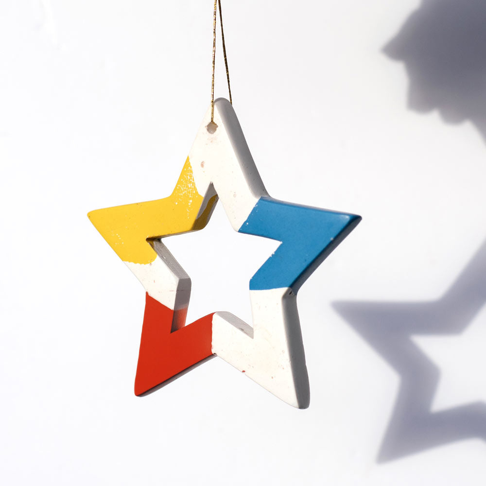 Colorful star-shaped ornament hanging against a white background