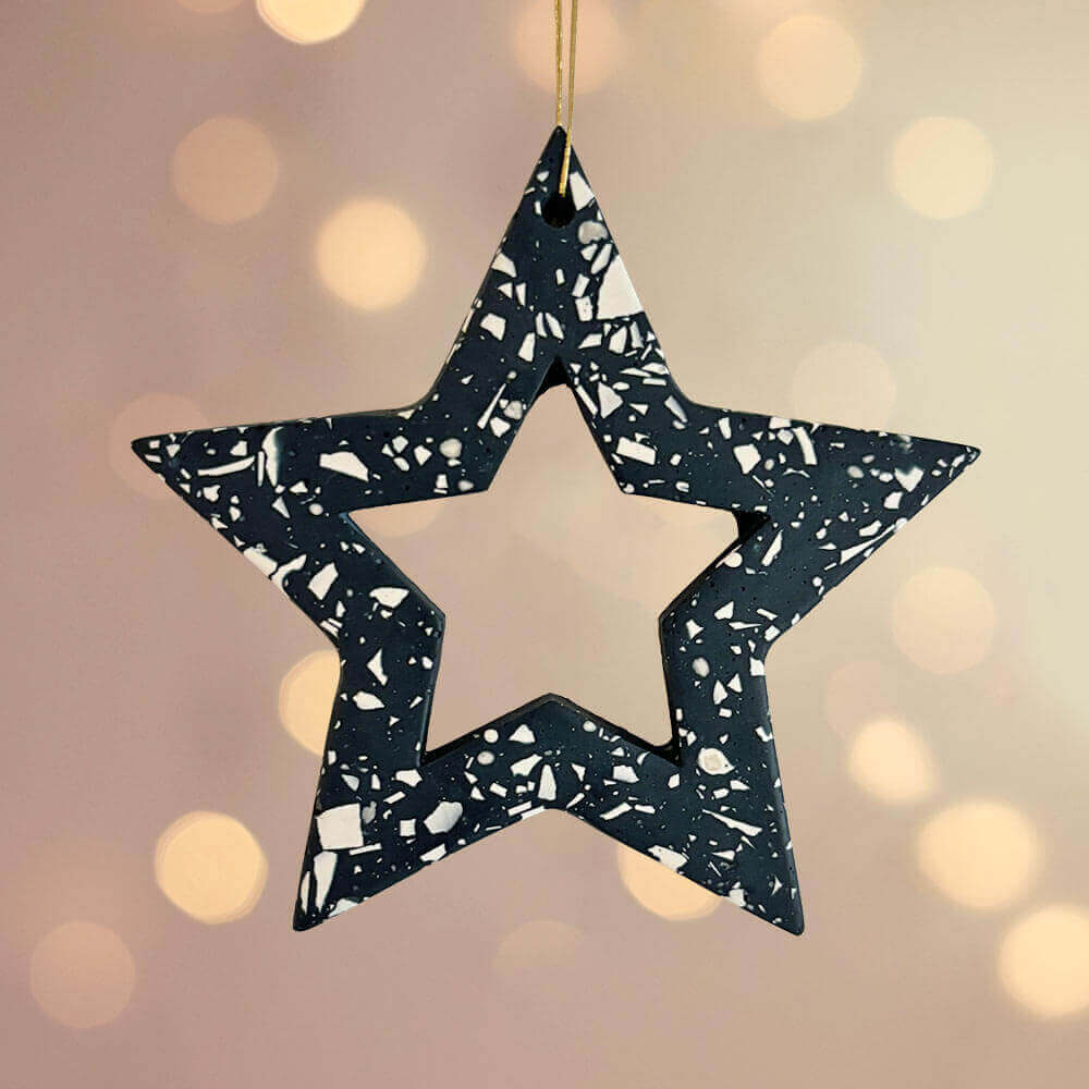 Navy terrazzo star Christmas ornament on a blurred light background
