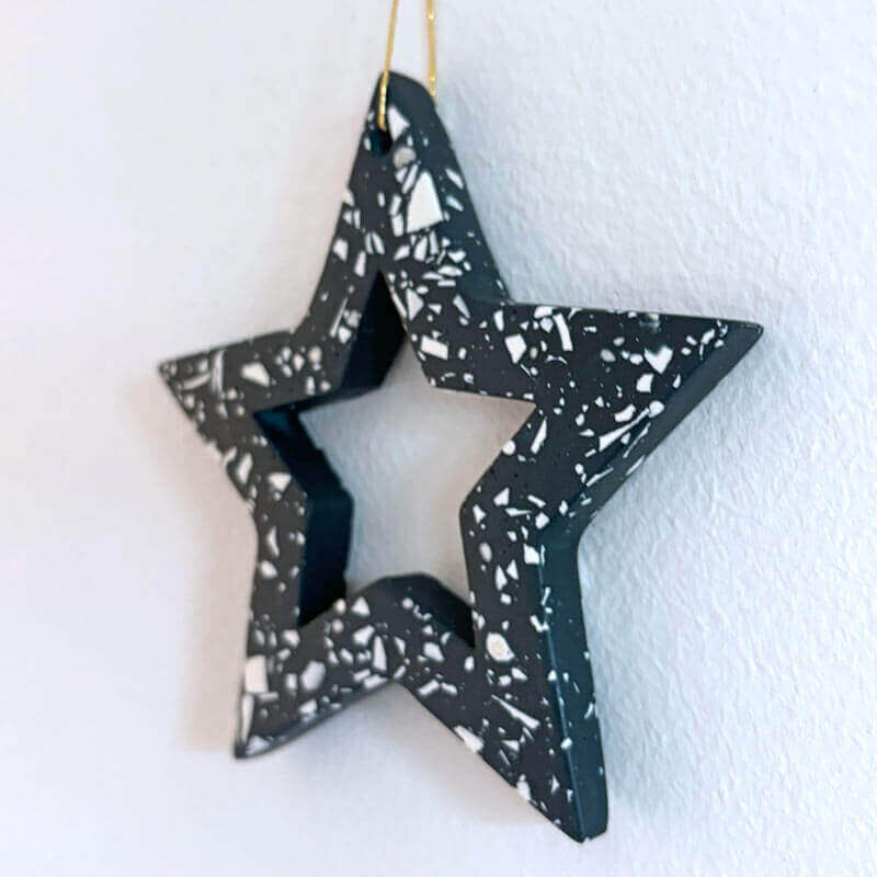 Navy with white terrazzo star hanging against a white wall.