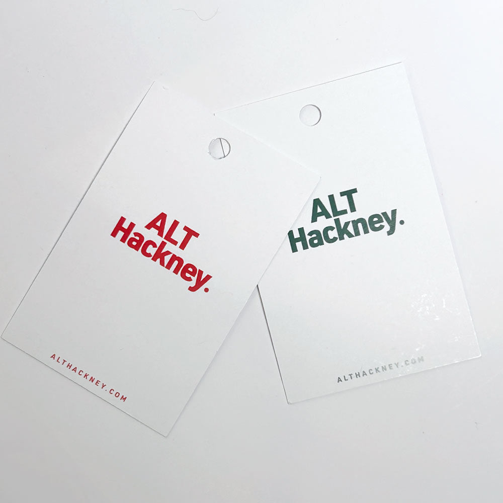 Two white holiday display card with holes at the top, printed with the ALT Hackney logo in red and green, displayed on a clean white background.