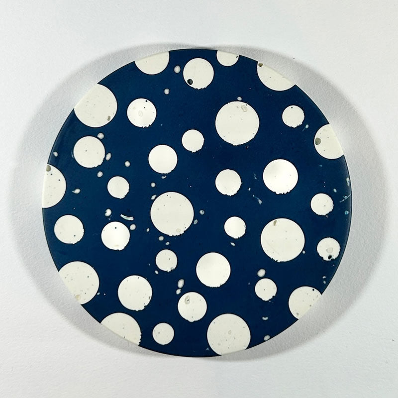 Navy and white round dot coaster on a white background