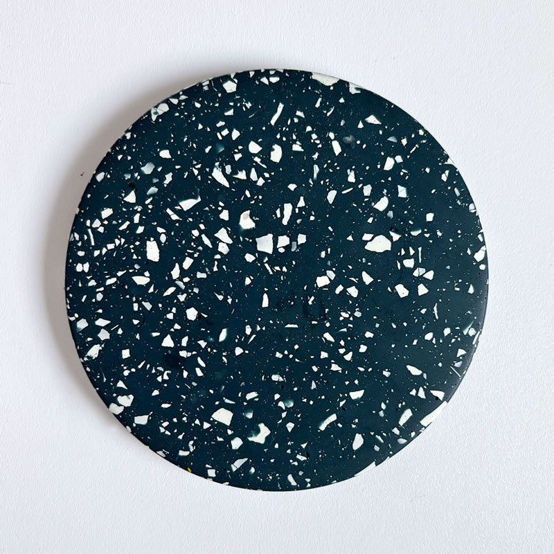 Navy terrazzo round coaster on a light gray background