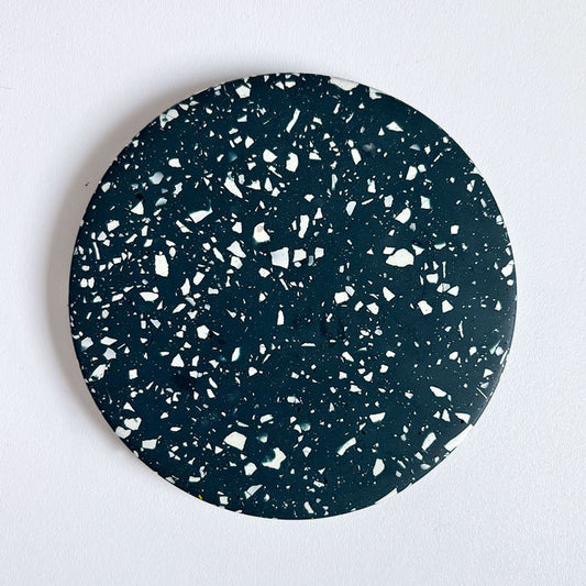Navy terrazzo round coaster on a light gray background