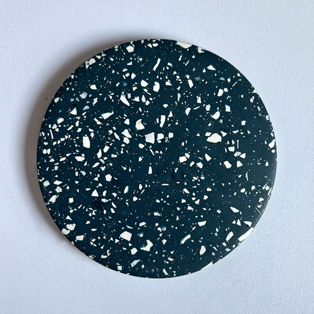 Navy terrazzo round coaster on a light gray background
