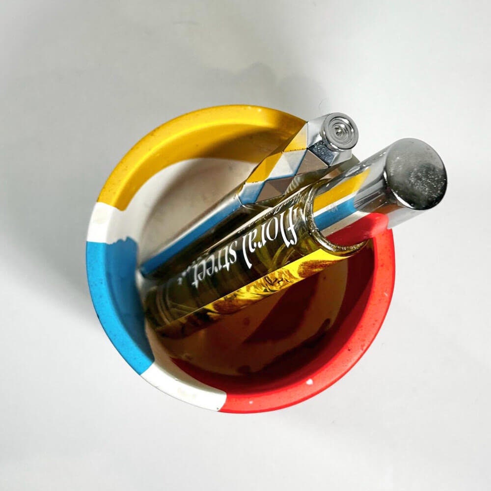A perfume bottle, a makeup silver pen with colourful pen holder on a white background