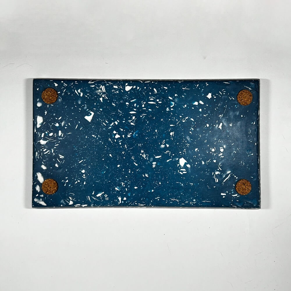Navy tray with white speckles with corks on a white background