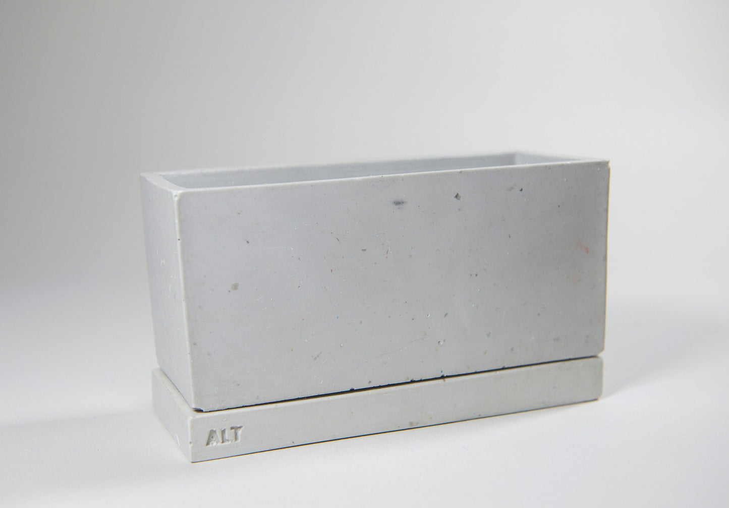 Rectangular grey planter with drainage holes and a water tray box with 'ALT' branding on a white background
