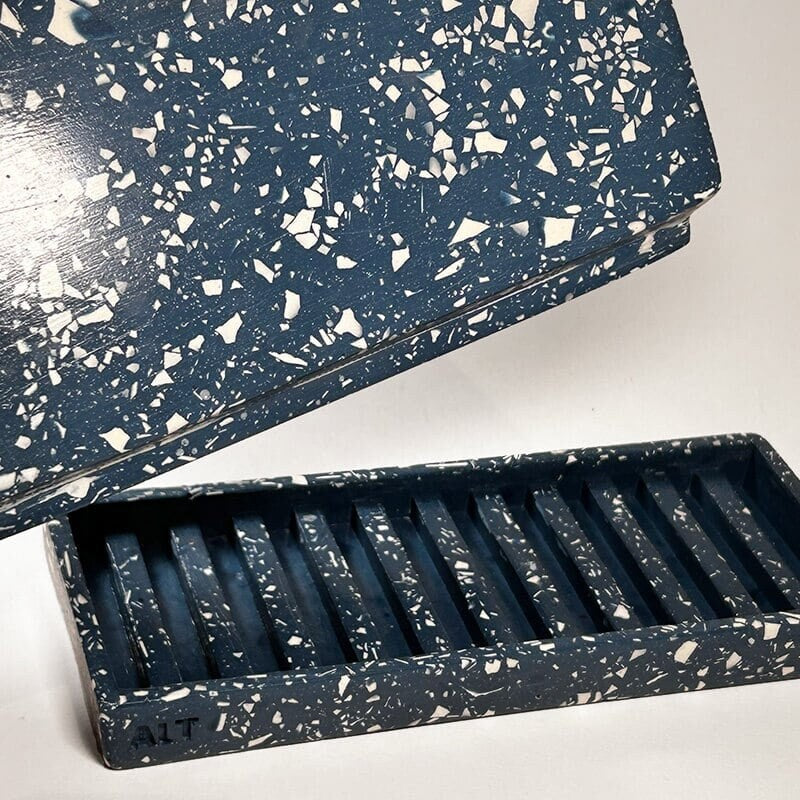 Close up of a navy rectangular terrazzo planter with drainage holes and a water tray on a white background