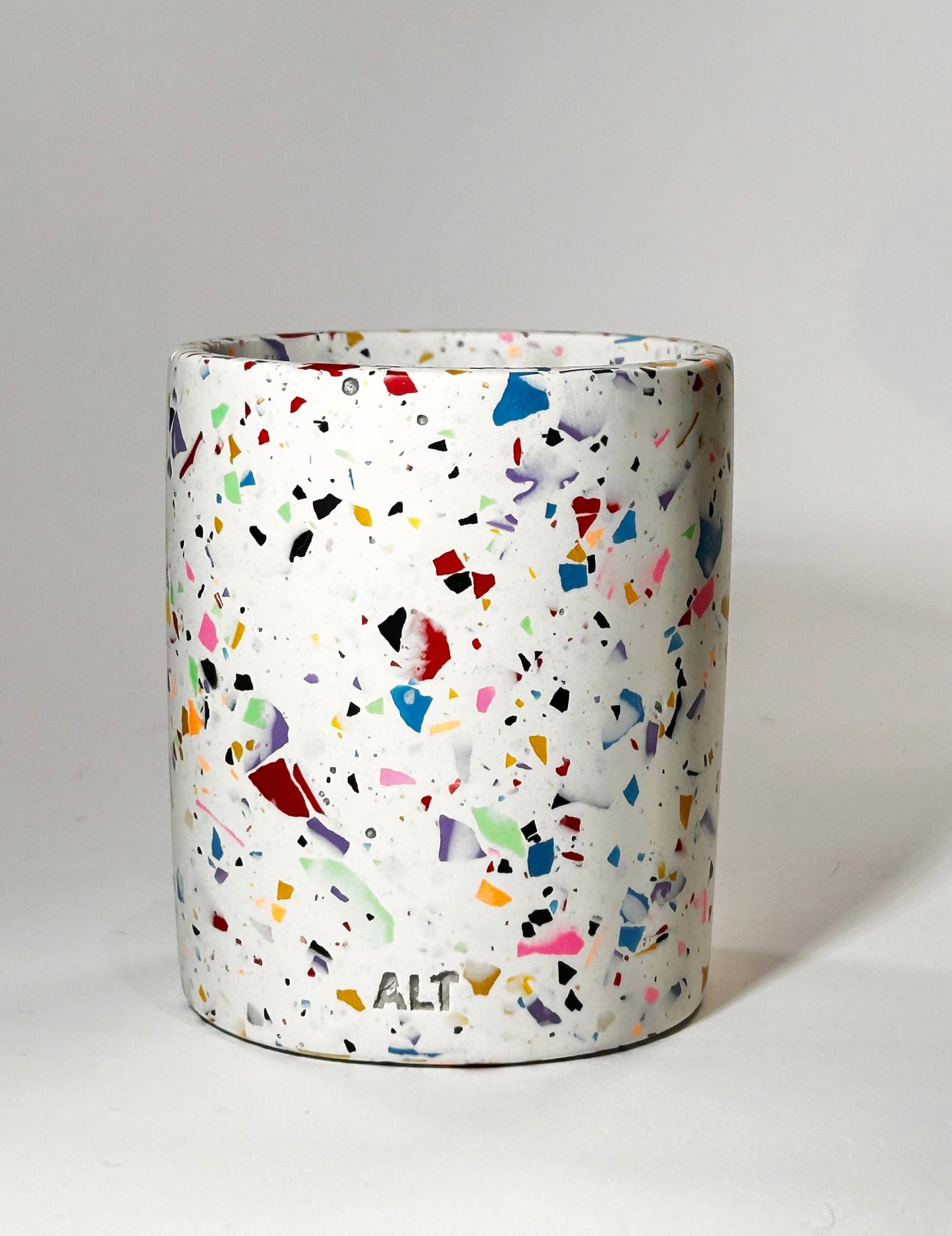 Cylindrical container with multicolored speckled pattern on a white background