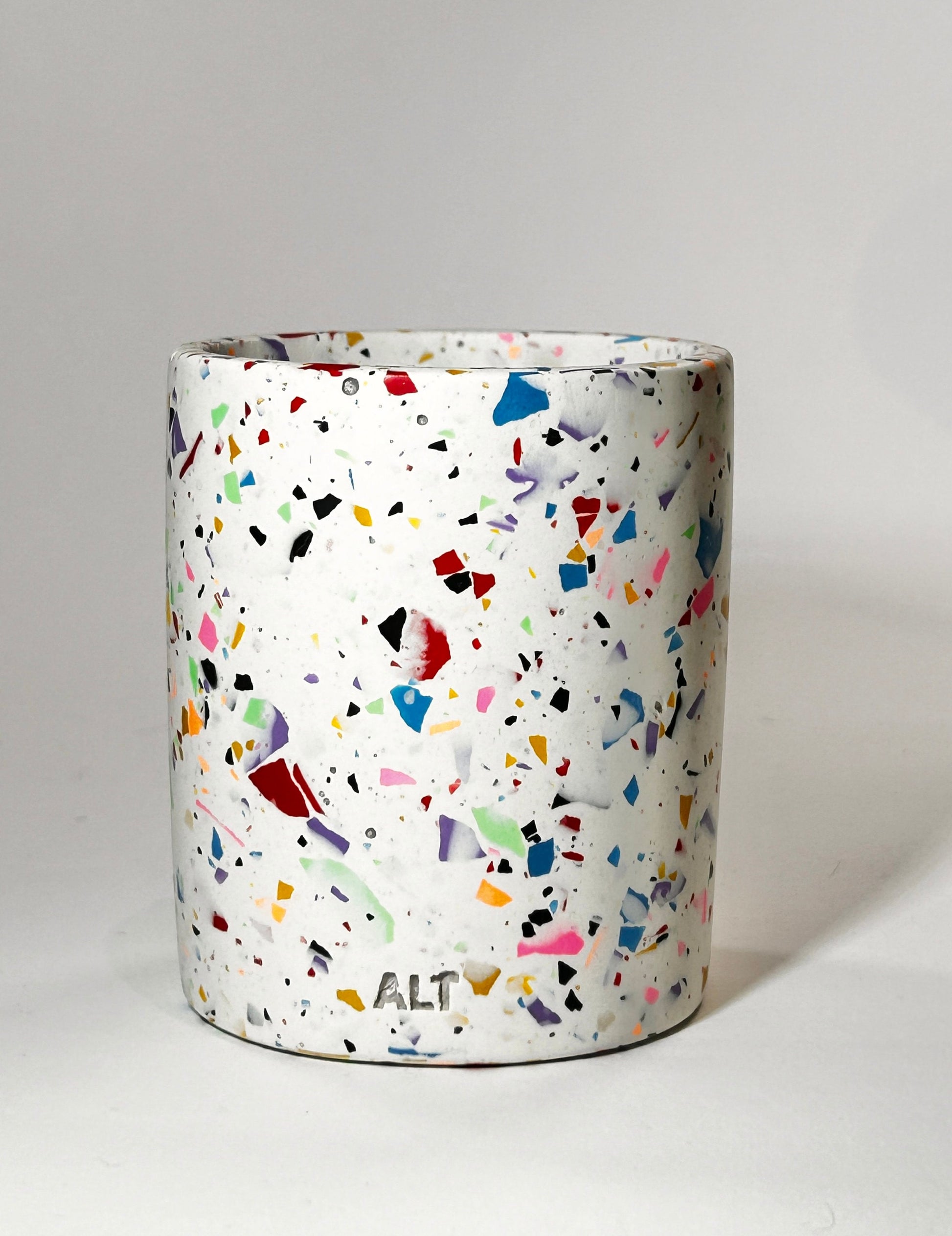 Cylindrical container with multicolored speckled pattern on a white background