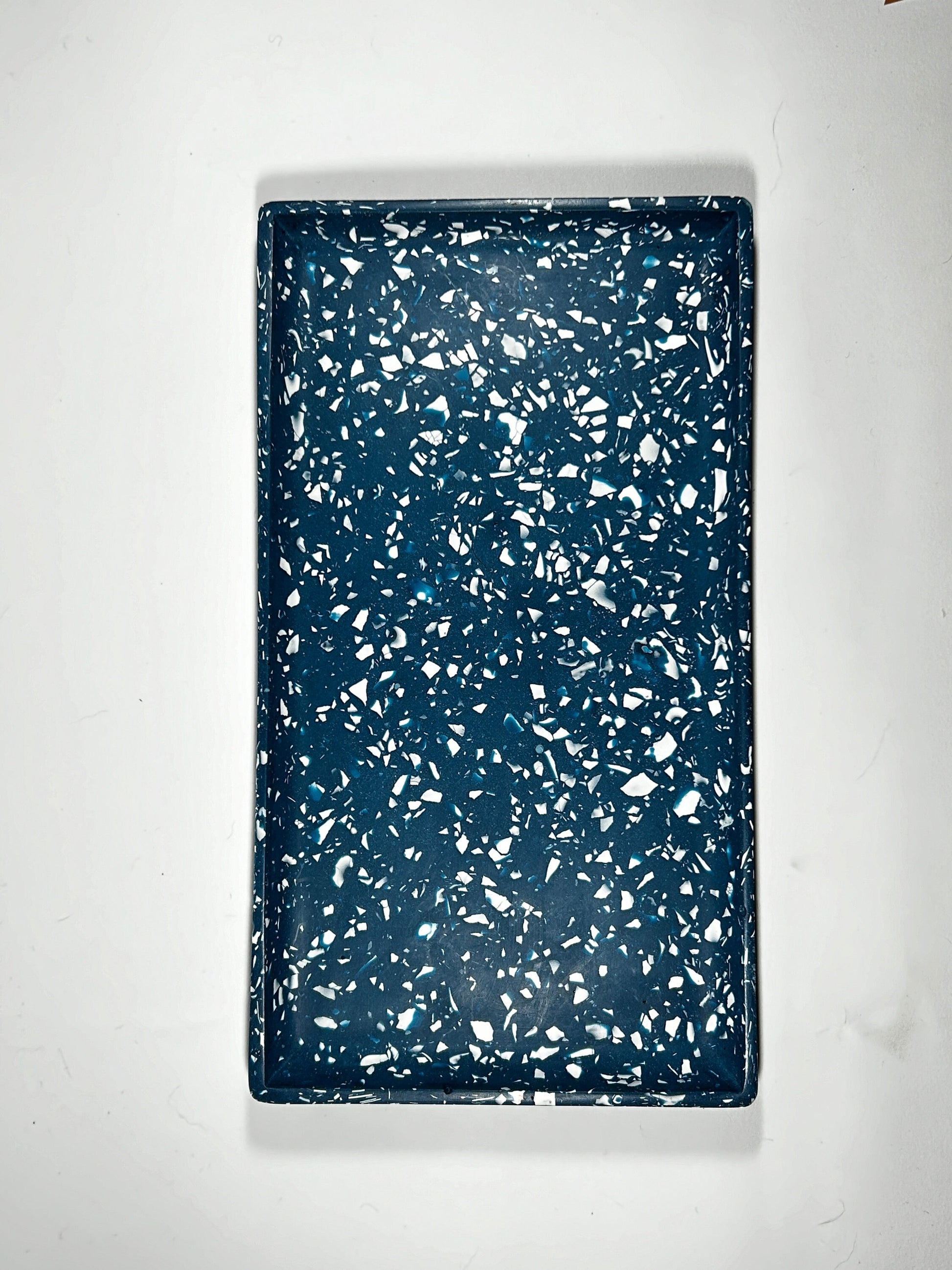 Navy tray with white speckles on a white background