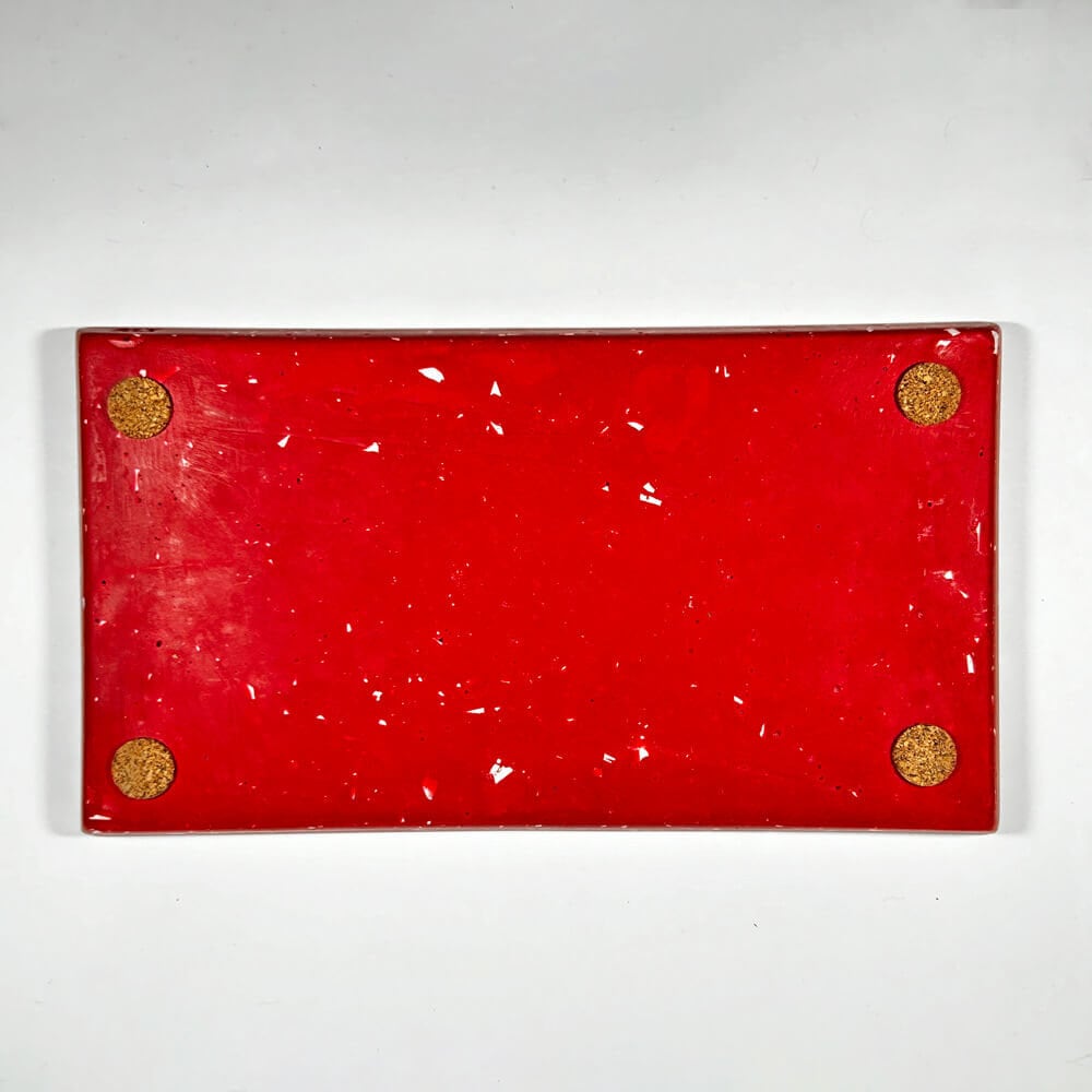 Red rectangular tray with corks on a white background