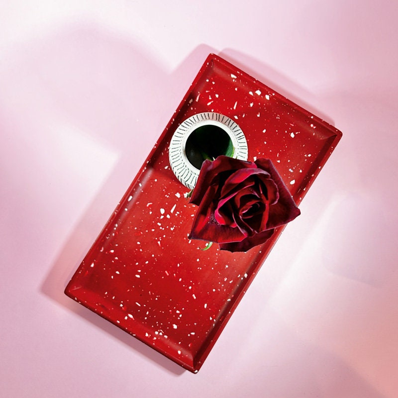 Red terrazzo tray and a vase with a rose on a pink background