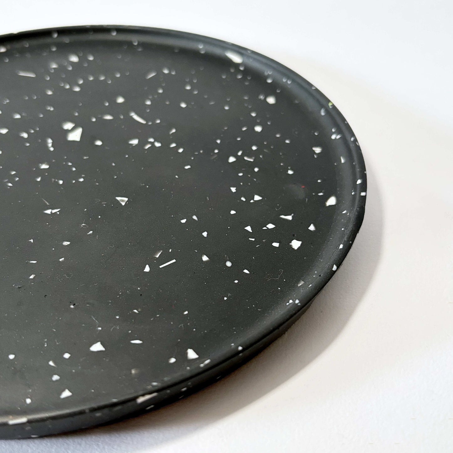 Black speckled decorative tray on a white background