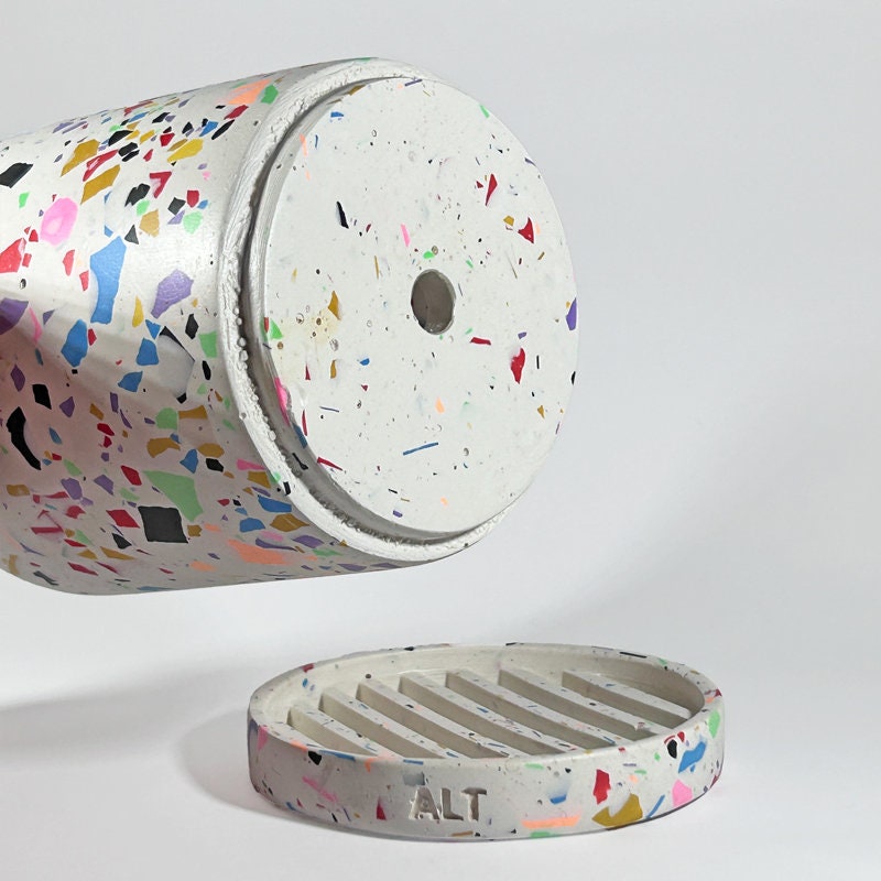 Colourful terrazzo-patterned plant pot with drainage hole and a separate water tray on a white background