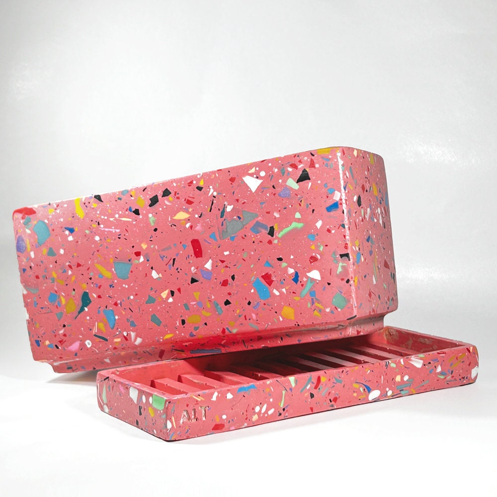 Pink rectangular plant pot with colourful speckles terrazzo with drainage holes and a water tray on a white background