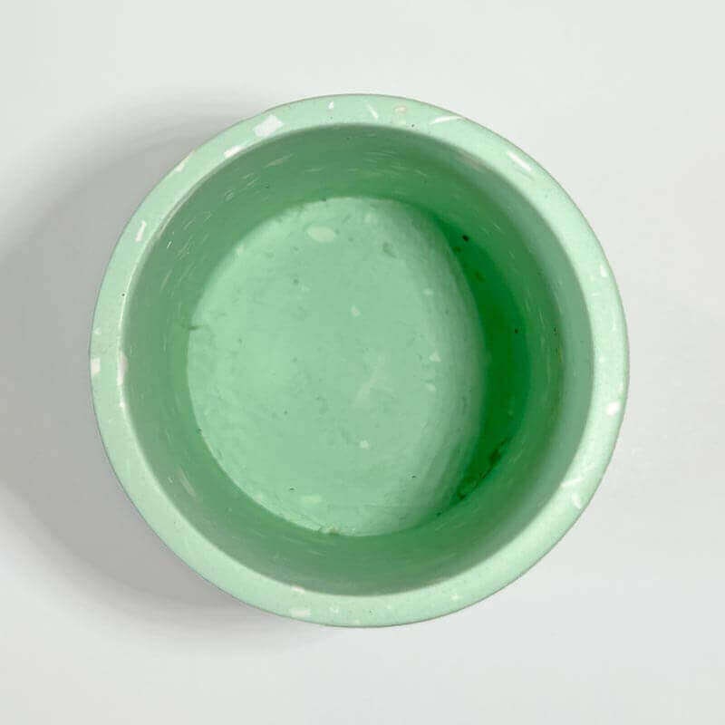 Mint green pen pot on a light grey background