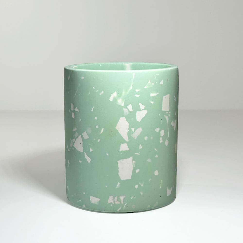 Mint green pen pot on a light grey background