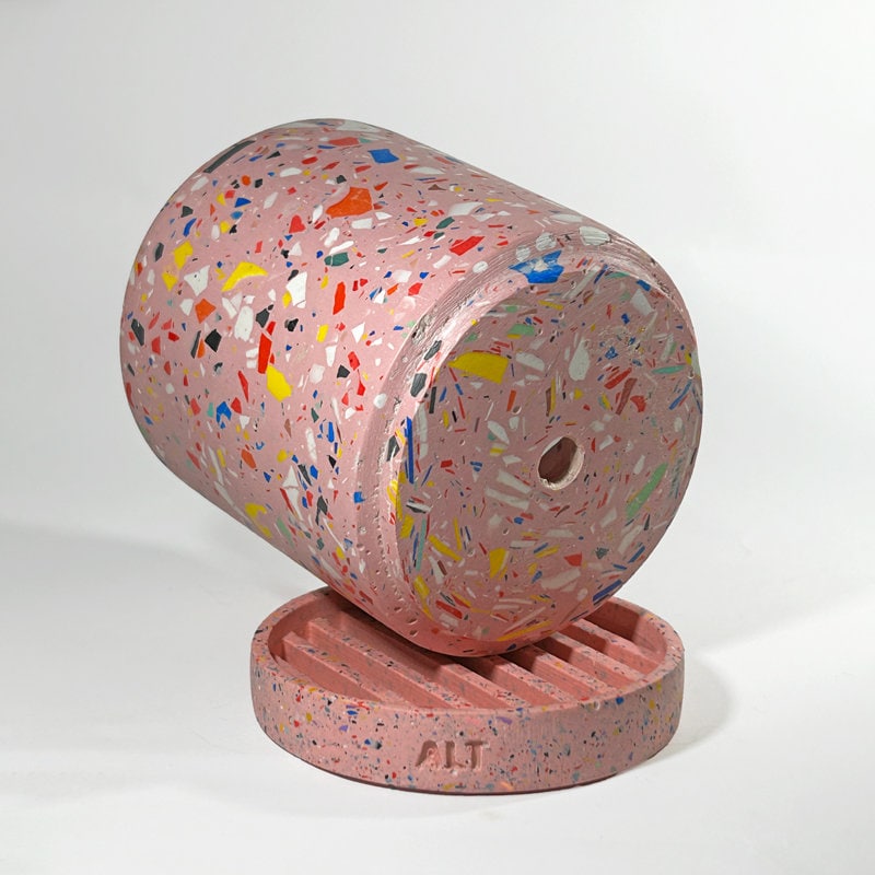 Pink terrazzo-patterned planter with a drainage hole and a water tray on a white background
