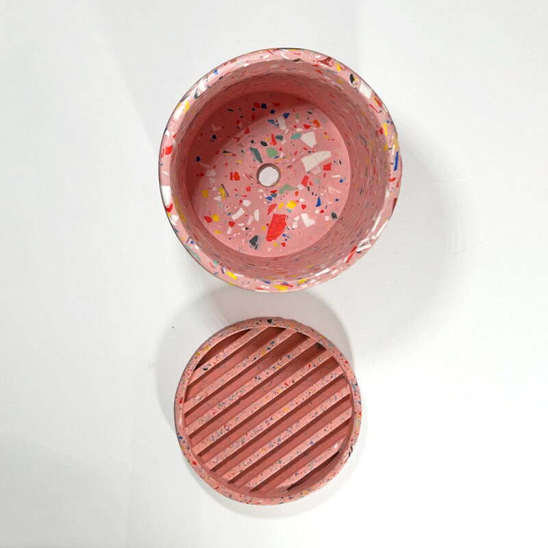 Pink terrazzo-patterned planter with a drainage hole and a water tray on a white background