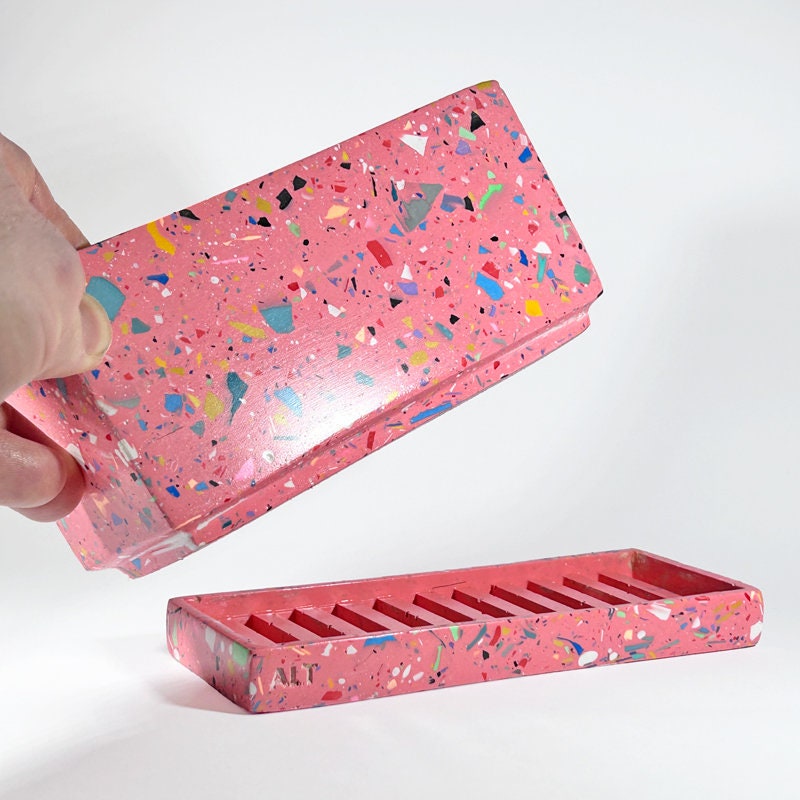 Pink rectangular plant pot with colourful speckles terrazzo with drainage holes and a water tray on a white background