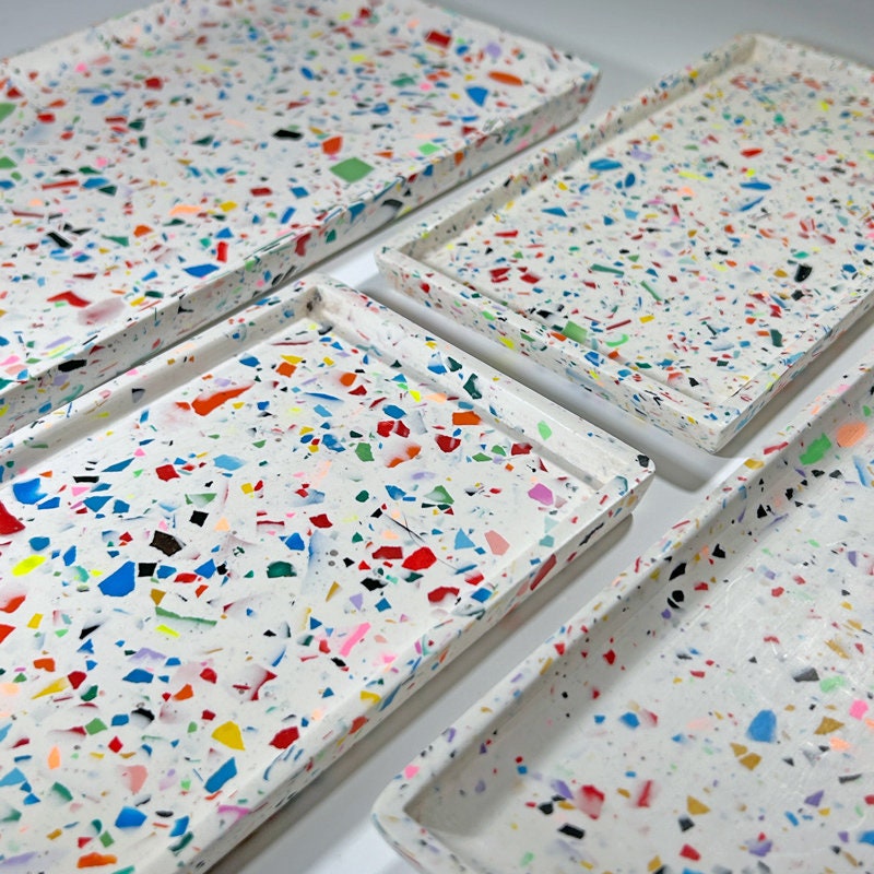 Colourful rainbow confetti terrazzo decorative trays displayed on a white surface
