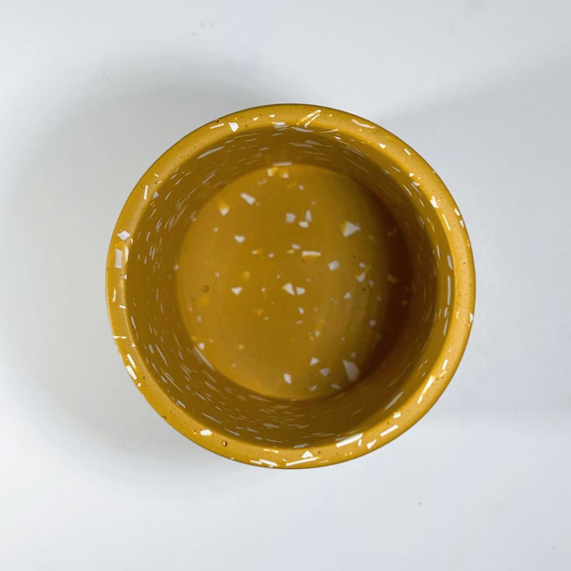 Yellow mustard pen pot with white terrazzo pattern on a white background