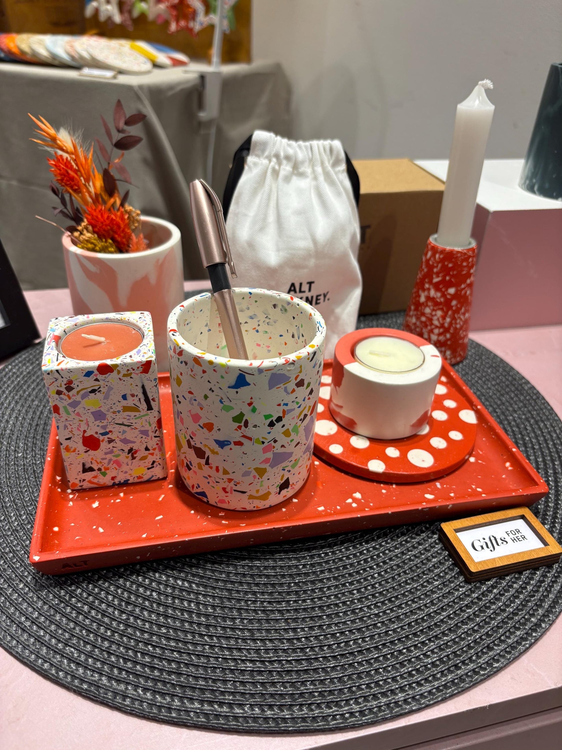 Colourful jesmonite homeware items on a table with a gift card in the foreground
